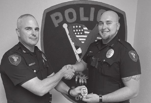 Madill Police Chief Steven Ray gives Sgt. Dustin Atnip his new badge after promoting him to Sergeant. Courtesy photo