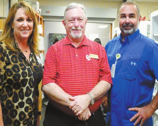 From left to right: Tina Davis, left, and Joe Burns, right, reward Phil Biddy, middle, for 50 years of service. Courtesy photo