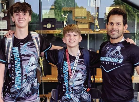 (L to R) Joey and Billy Arbuckle with Coach Peter HammeratMustangHighSchool.(Notpictured:Damian Robertson.) Courtesy photo