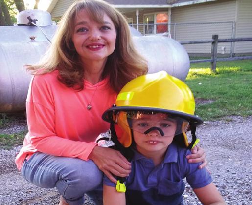 Lori Kenney and her nine-year-old hero Gavin. He was presented with an award from the Ens Fire Dept. for remaining calm and dialing 911 when his mom began choking in February. Brent Smith