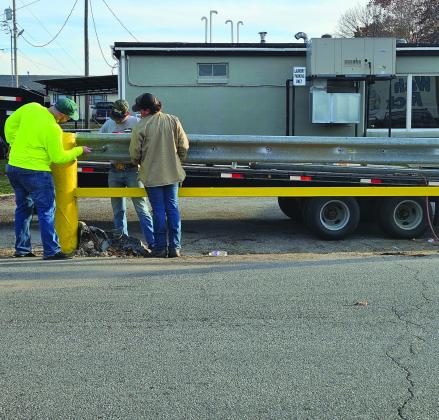Shalene White • The Madill Record On December 6, a semi, pictured left, was exiting the car wash located at Wolf Street and US 70 and damaged the drainage grate and cement barricade impeding traffic for a few hours. Once the wreck was cleared, city workers began building a large yellow barricade, pictured right, to deter any future run ins.