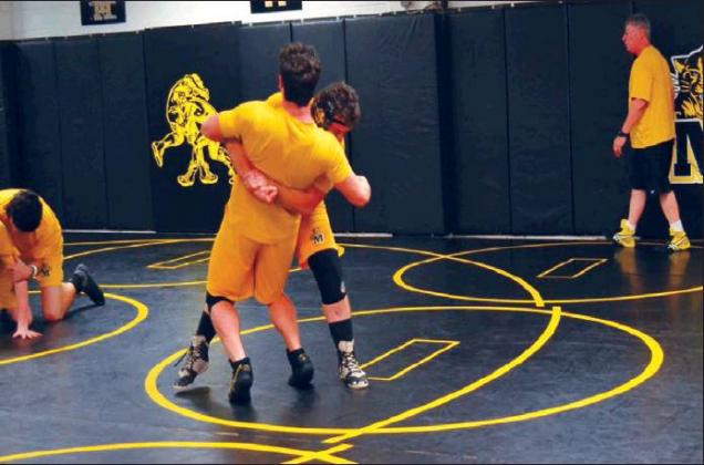 Matt Caban • The Madill Record Seniors John Venable (center left) and Coty Tweety (center right) grapple during takedown drills at a Madill High School Wildcat wrestling practice Jan. 13 while Head Coach David Love (far right) looks on. The team began the 2020 portion of its schedule with a fifth place finish at the Pauls Valley Invitational Tournament Jan. 10-11.