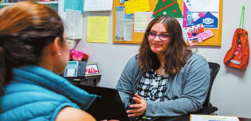 In this file photo, Taylor Lott, who worked as navigator to increase health insurance enrollment under the Affordable Care Act, talks to Andrea Chica at the Latino Community Development Agency office in Oklahoma City. Funding cuts and the pandemic are complicating efforts to get Oklahomans registered before the Dec. 15 deadline this year. (Mashiur Rahaman/Oklahoma Watch)