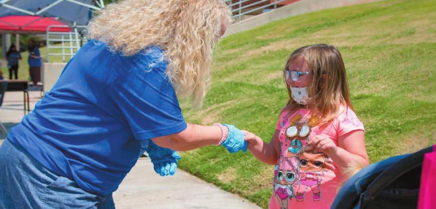 Rayne Ryan, 5, shakes hands with her new kindergarten teacher, Terri Cox, outside of Eugene Field Elementary School on Aug. 24, 2020. Most students met their teachers from their cars at a drive-thru meet and greet held by the school Monday, but Rayne’s family walked to the school. (Whitney Bryen/Oklahoma Watch) Courtesy photo