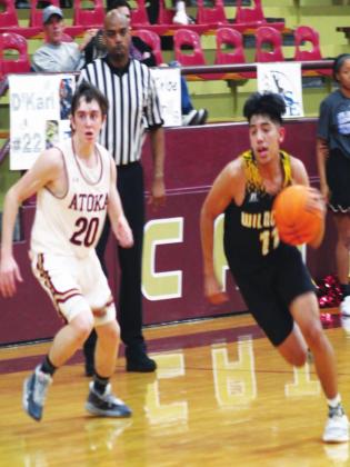 Madill junior guard Ezekial Fuentes (11) dribble past an Atoka defender during a game on Feb. 14. Fuentes scored nine points in the Wildcats’ winning effort over the host Wampus Cats. The win moved Madill to 17-5 on the season. Glenn Price • The Madill Record