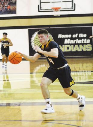 Madill senior forward Asa Robertson (4) dribbles the ball in a Feb. 17 game at Marietta as his teammate, junior guard Ezekial Fuentes (11) watches on. Glenn Price • The Madill Record