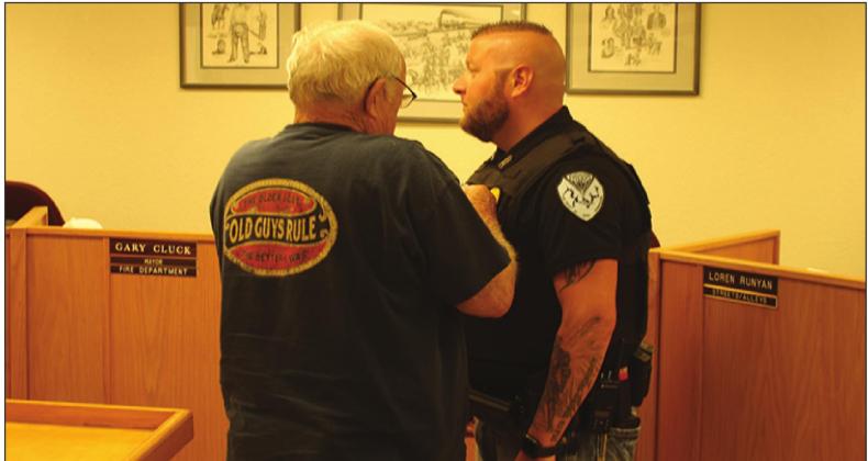 Cox receives his Chief badge from hjis grandfather, Sonny Fennel during the Kingston City Council meeting. Gary Jackson • The Madill Record