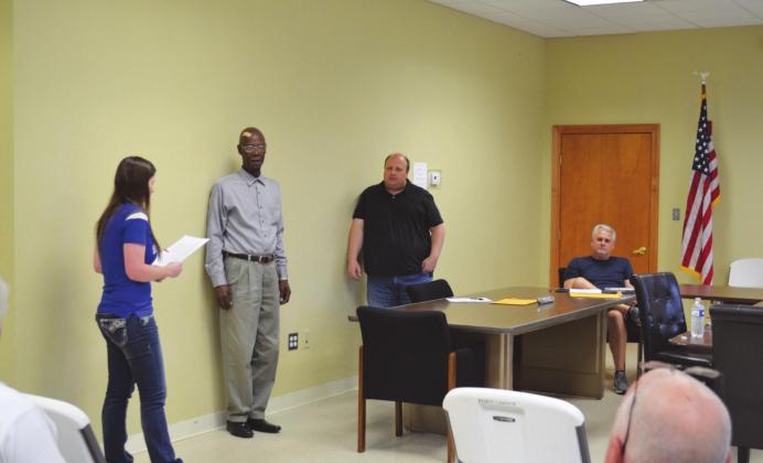 Madill City Attorney Kristen Speer (left) administers the Oath of Office to Madill city council member Bobby Davis (second from left) as fellow council members, Travis Williams, (center) and Terry Rushing (right) look on. Matt Caban • The Madill Record