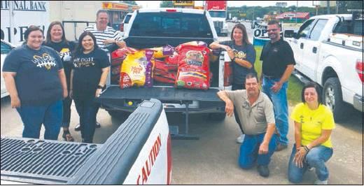 Courtesy Photo The employees at 1st National Bank raised money to purchase dog and cat food for the Madill Animal Shelter. They were able to donate 700 lbs of dog and cat food to the Madill Animal Shelter to help out with food to feed the overabundance of animals they have received. Pictured from left to right are: 1NB Employees: LizBeth Phillips, Andrea Porterfield, Julissa Jasso, Sam Huffman, Tara Roberts and Madill City Manager James Fullingim, Madill Animal Control James Tezehouse and Abigail Stauffer.