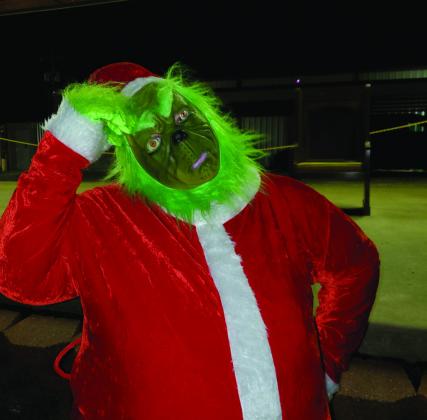 Crystal Burnezky-Robertson • The Madill Record State Representative Josh Cantrell, pictured left with son, Jarron, said parades are a bonding moment. The Grinch, pictured right, attended the Kingston Christmas Parade on December 9.