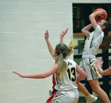 Jayden Weiberg goes for a layup while Braylee Scneider helps with the assist. Summer Bryant •The Madill Record